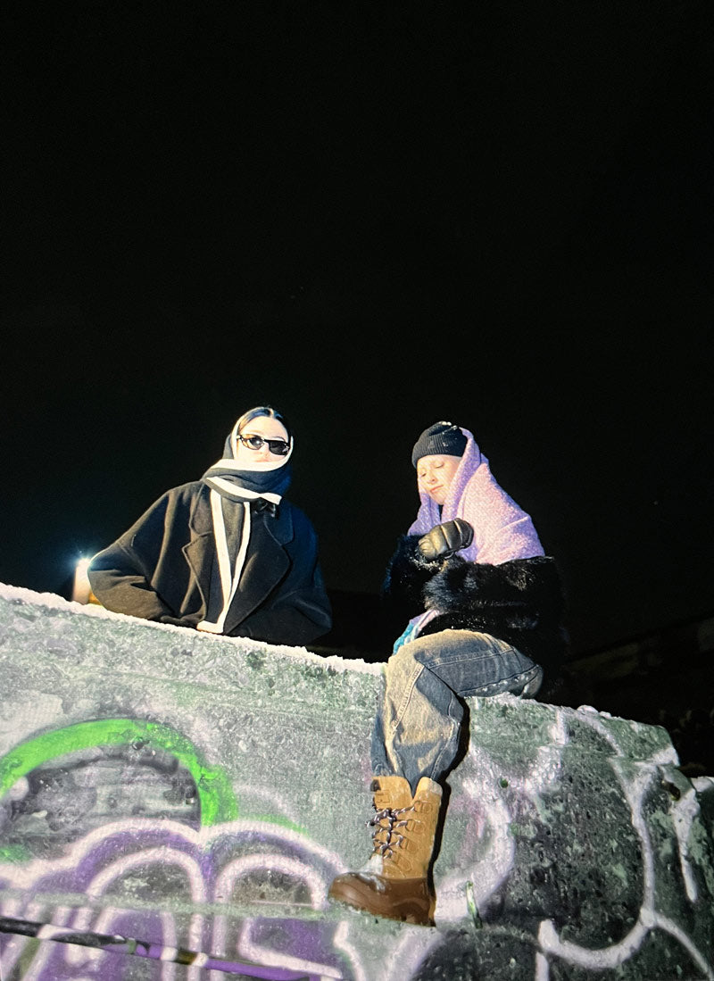 Young woman sitting on a cement block wearing Kamik Alborg winter boots