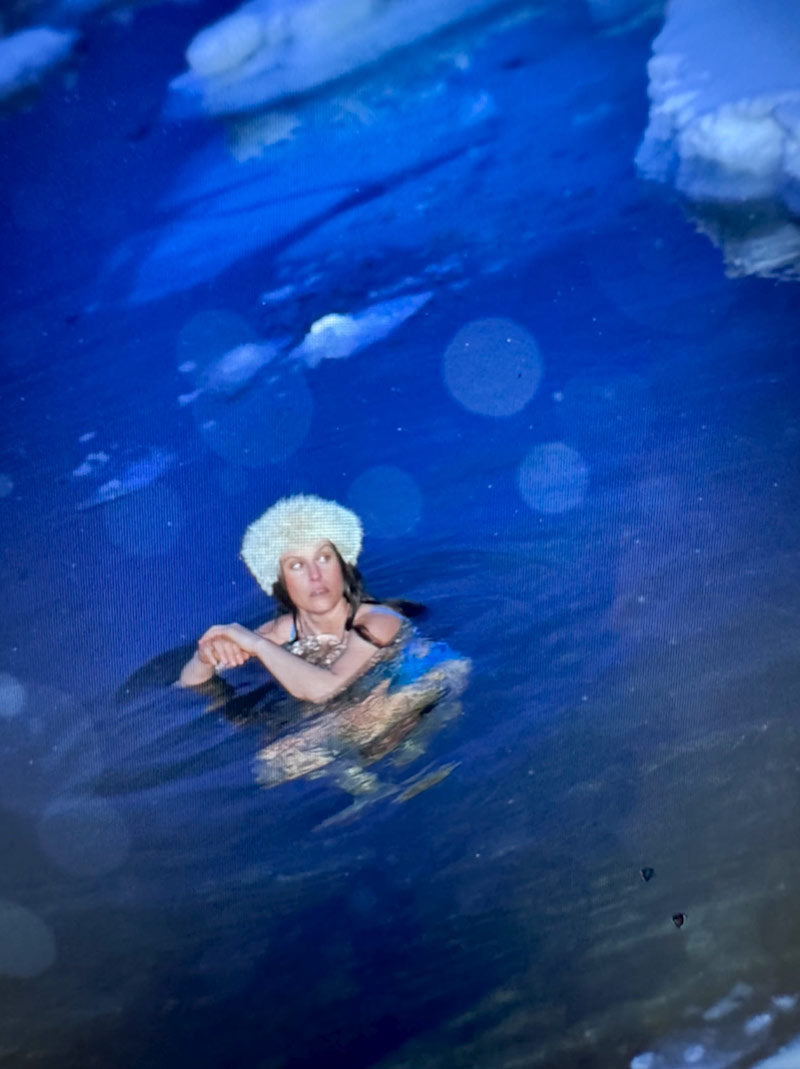 Woman wearing a fur hat doing an ice  plunge