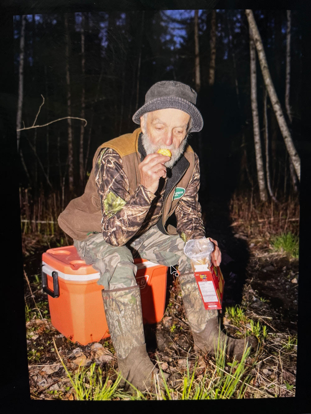 Man eating crackers in hunting gear wearing Kamik Fld Day camouflage boots