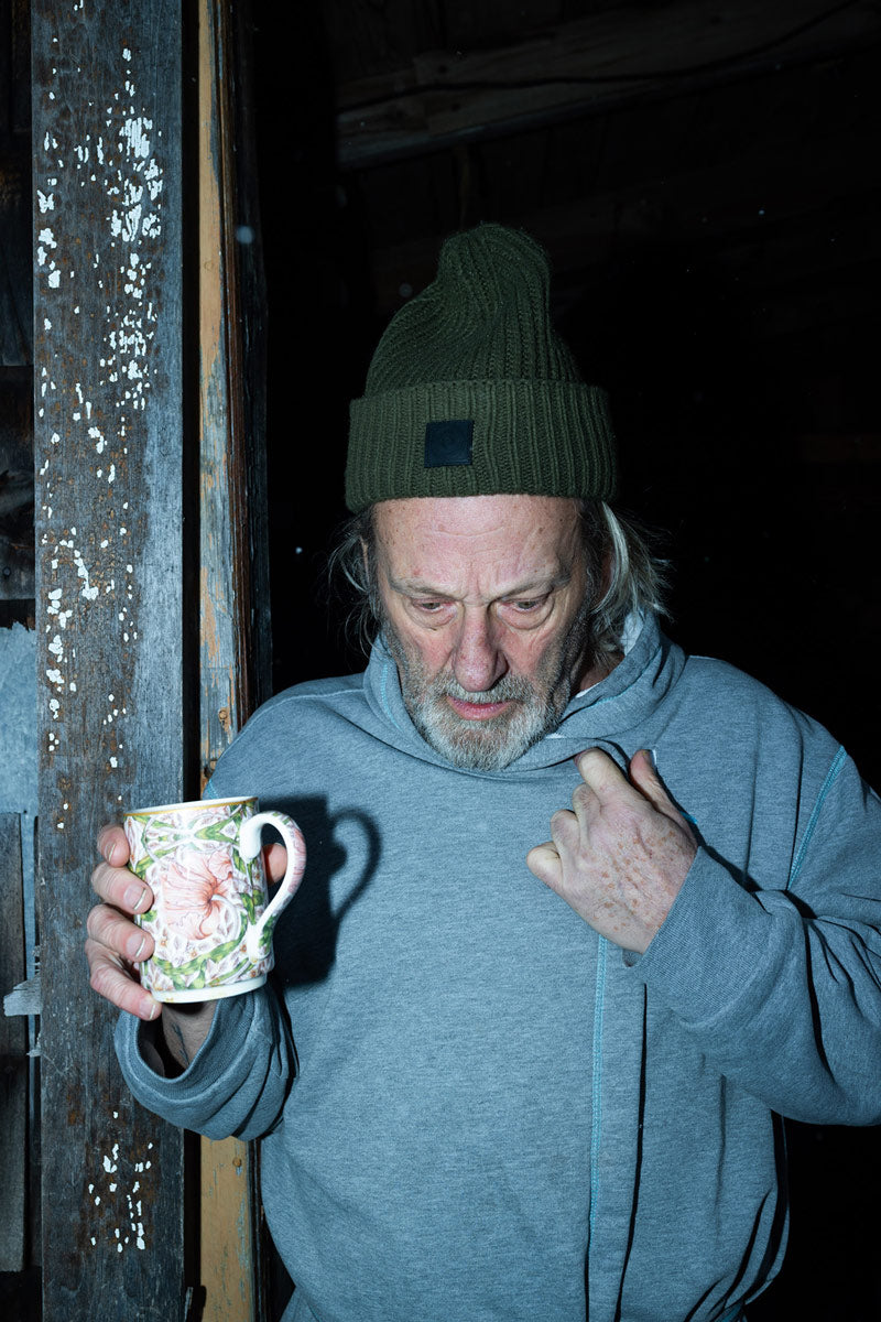 Man drinking a coffee in his bathrobe outside in cold weather