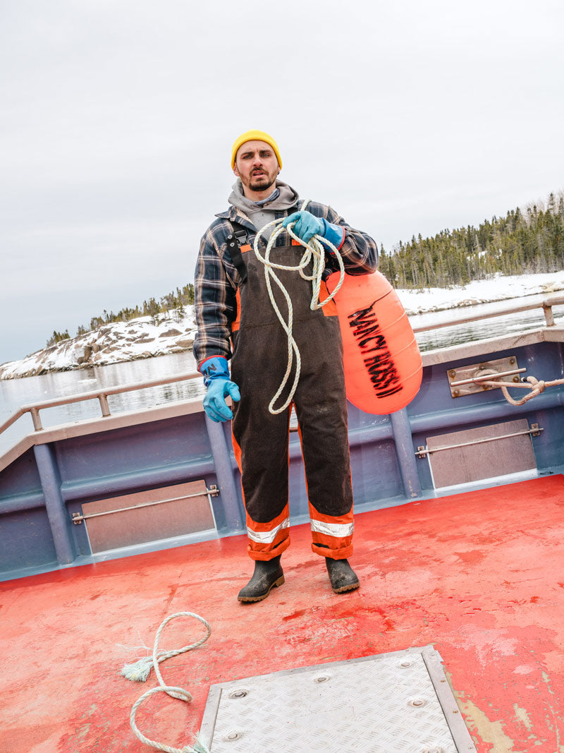 Man wearing Kamik Workhorse waterproof rain boots on a boat