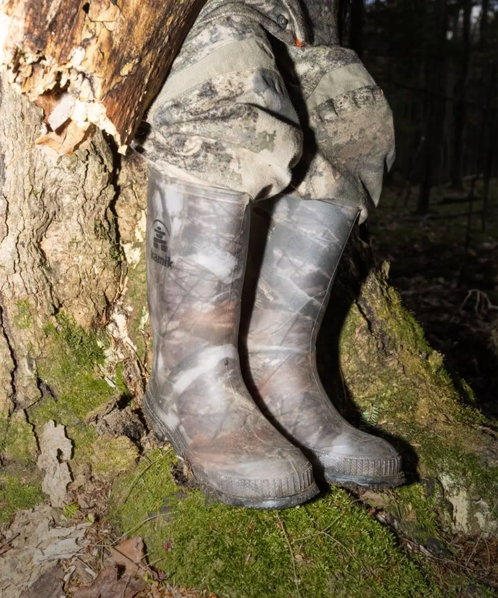 Kid dressed in hunting gear wearing camouflage Stomp rain boots