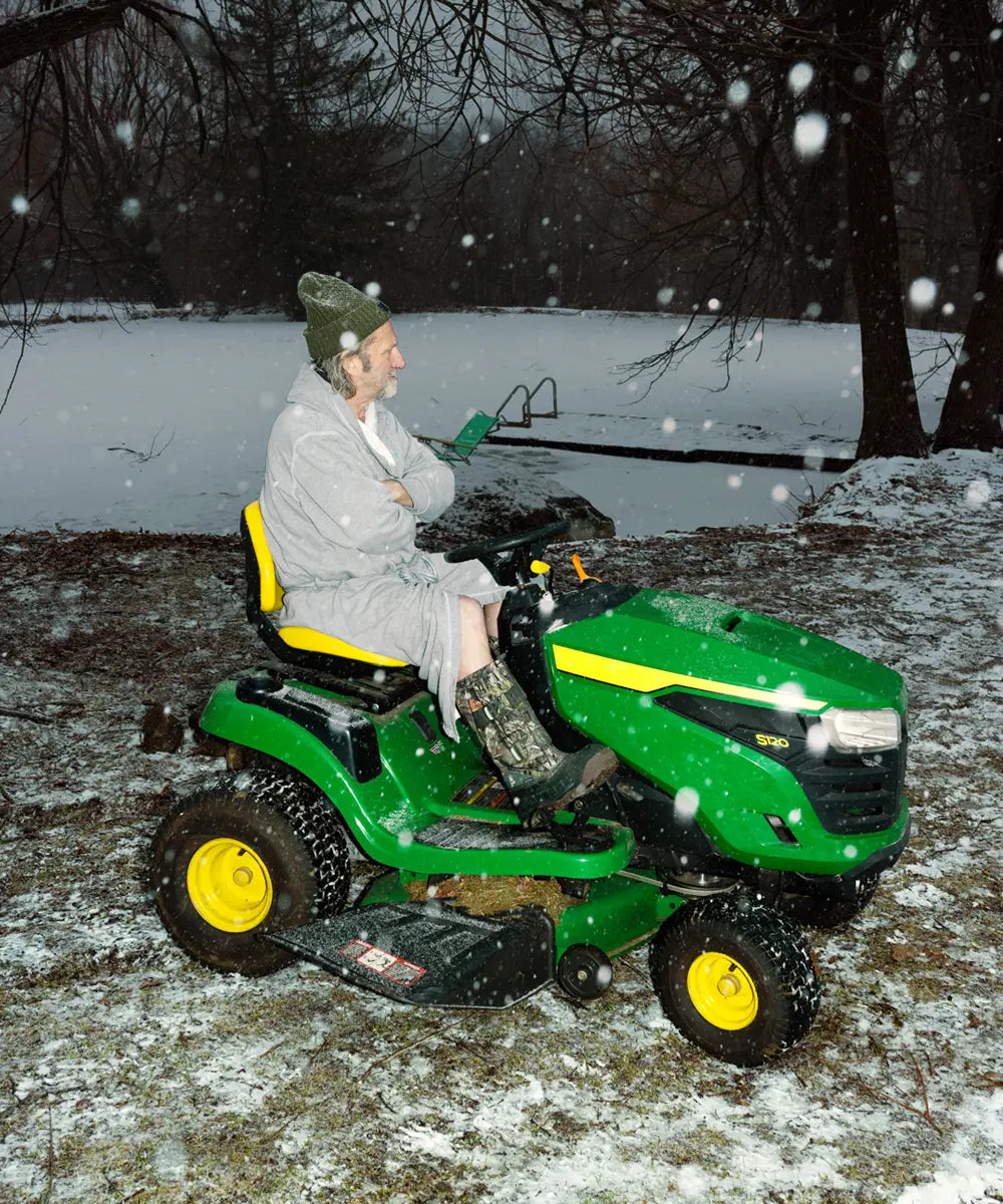 Man mowing his lawn in the snow while wearing Kamik Cody XT winter boots